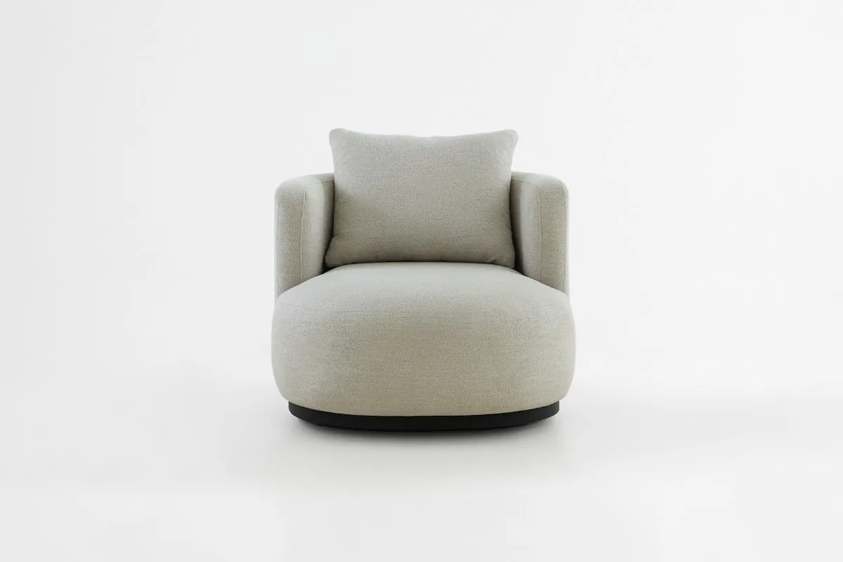 Rounded light grey bouclé swivel armchair with a plush loose back cushion and a dark circular plinth base, on a plain white background.